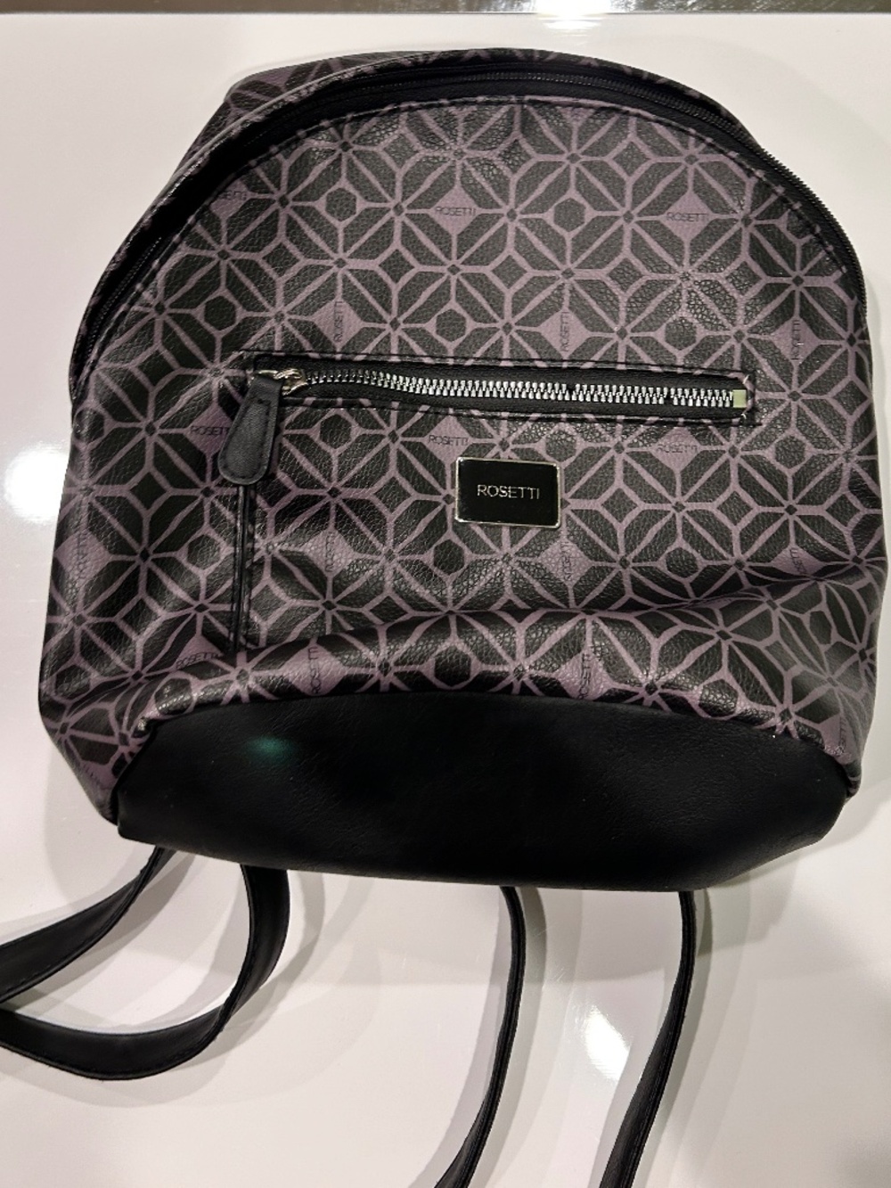 Cute mini backpac featuring an allover geometric pattern black trim rounded silh